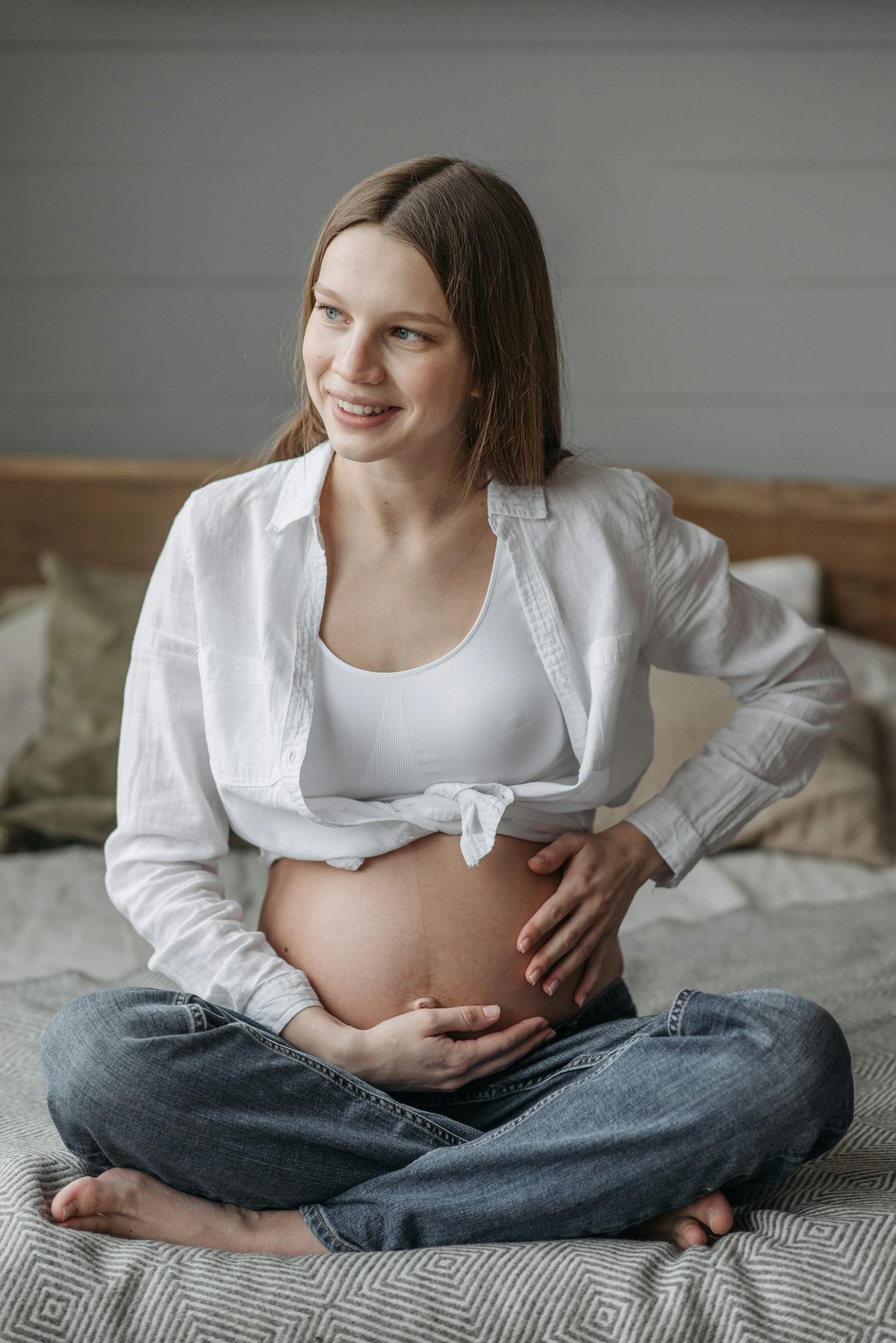 Femme enceinte sereine, assise en tailleur
